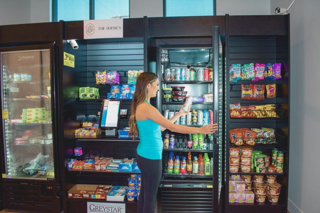 A young woman selects items from a micro market at an apartment building.